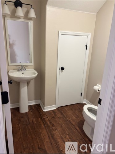 A bathroom with a white sink and toilet.