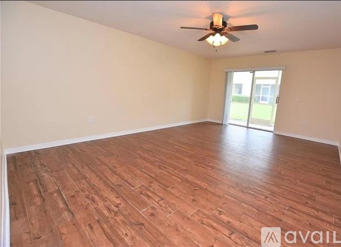 A room with wooden flooring and a ceiling fan.