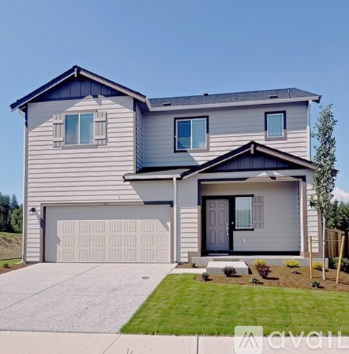 A modern house with a grey and white exterior and a black front door.