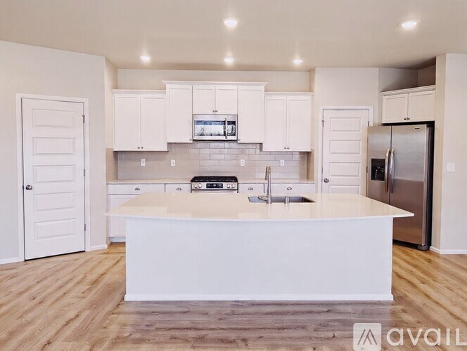 A modern kitchen with white cabinets and a central island.