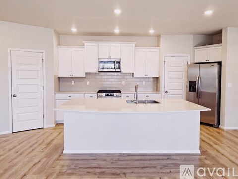 A modern kitchen with white cabinets and a central island.