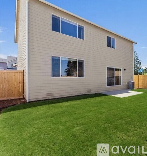 A house with a brown fence and a green lawn.