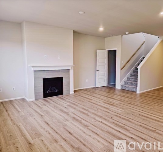 A living room with a fireplace and wooden floors.