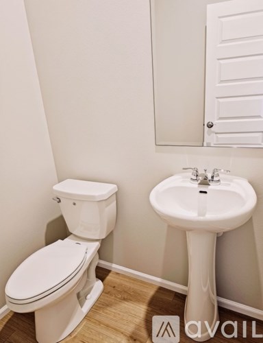 A white toilet and sink in a small bathroom.