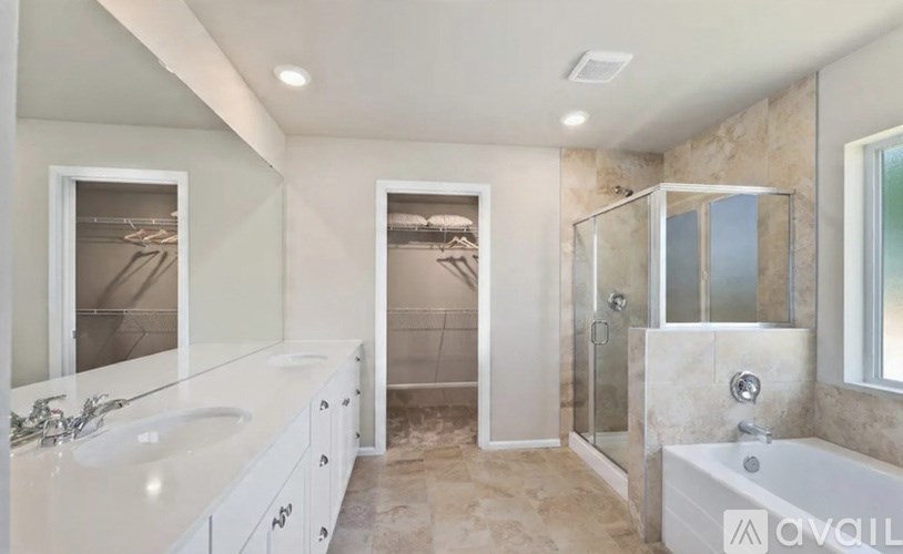 A bathroom with a tub, sink, and shower.