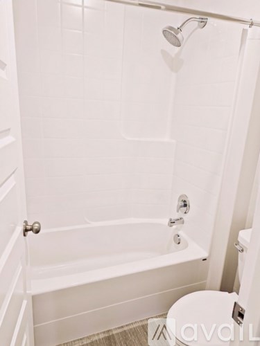 A white bathroom with a toilet and a bathtub.
