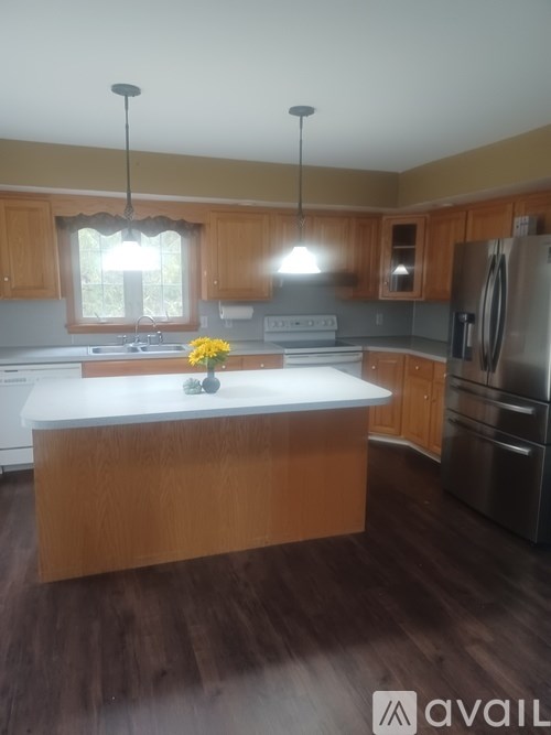 A kitchen with wooden cabinets and a white island.