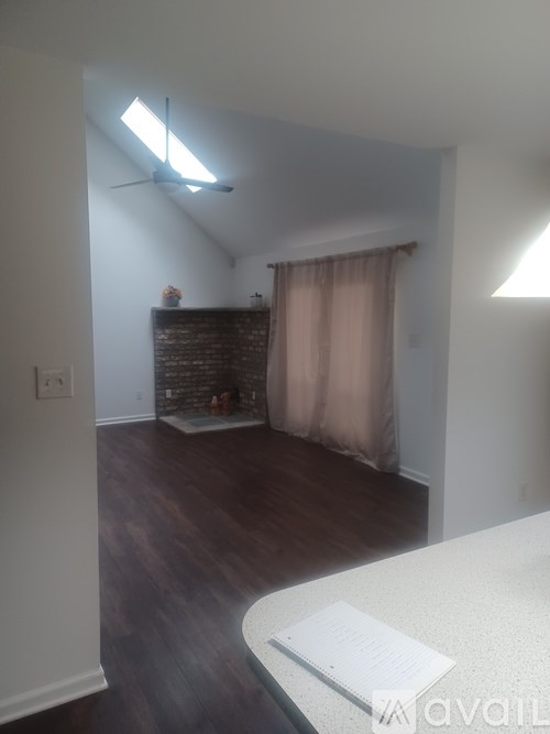 A room with a bed and a window with a skylight.