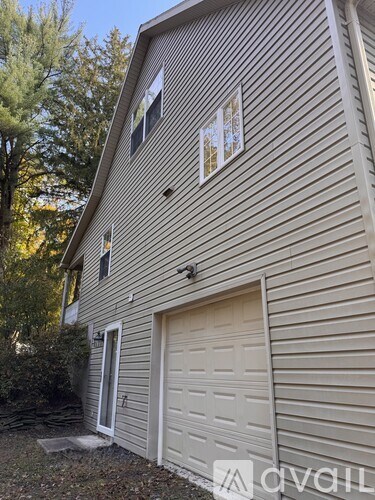 A house with a closed garage door and a small window above it.