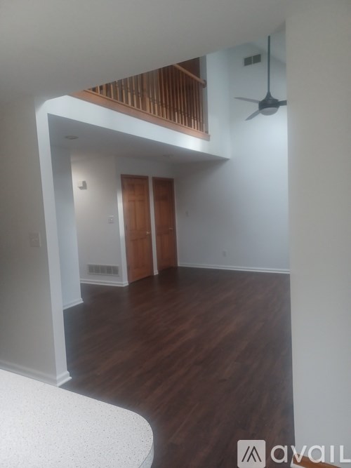 A room with wooden floors and a ceiling fan.