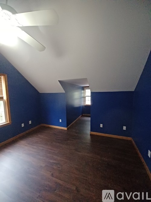 A room with a ceiling fan and a window.