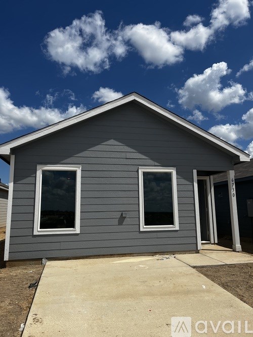A grey house with two windows and a door is for sale.