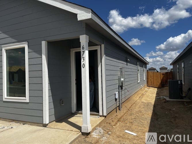 A grey house with the number 6303 on the front door.