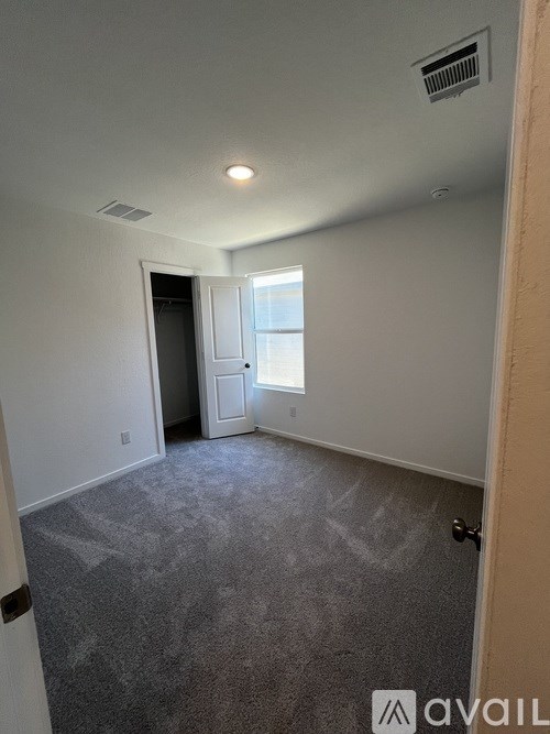 A room with a carpeted floor and a door leading to another room.