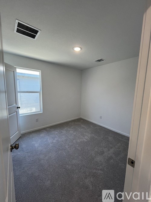 A room with a carpeted floor and a window.