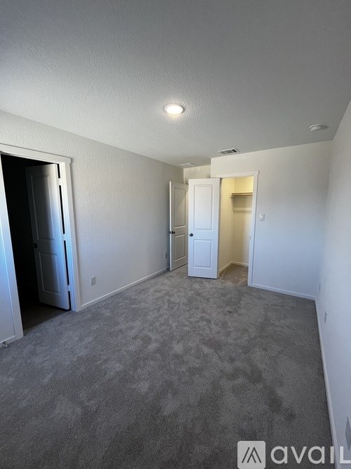 A room with a grey carpet and white walls.
