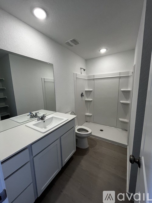 A bathroom with a toilet, sink, and mirror.
