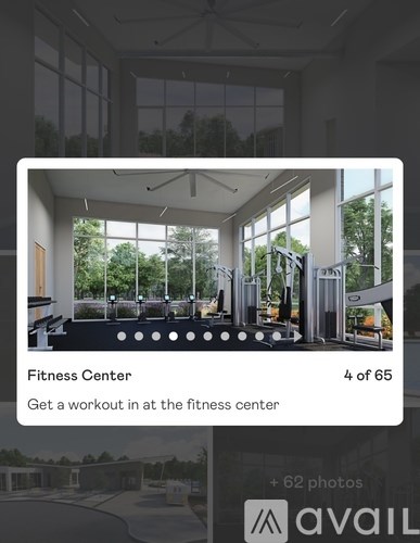 A fitness center with a variety of equipment and a view of trees outside the windows.