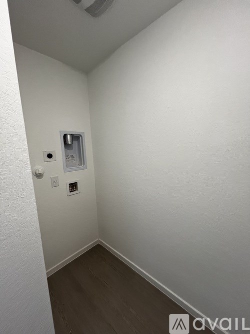 A white wall with a small window and a light switch.