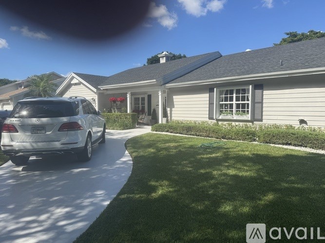 A white car is parked in front of a house with a logo that reads "AVAIL".