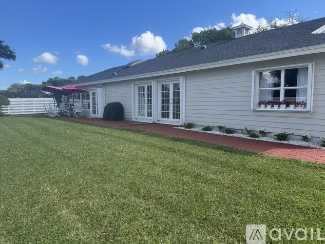 A house with a red awning and a white fence.