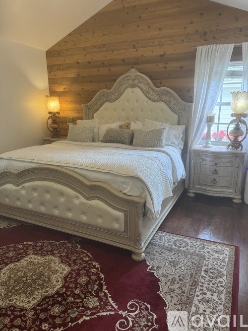 A bedroom with a large bed and a wooden ceiling.