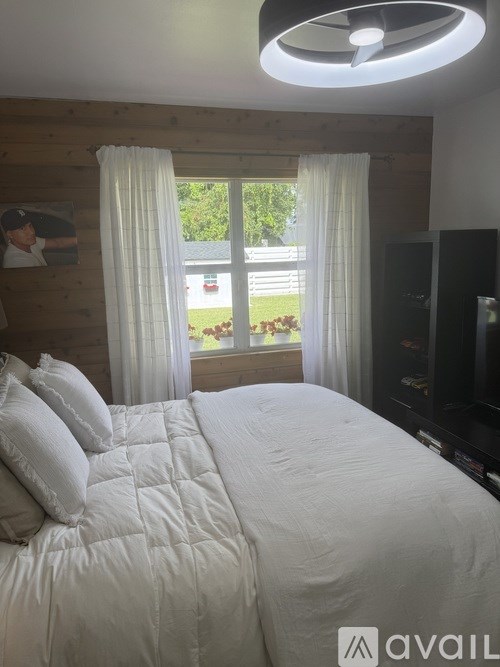 A bedroom with a large bed and a ceiling fan.