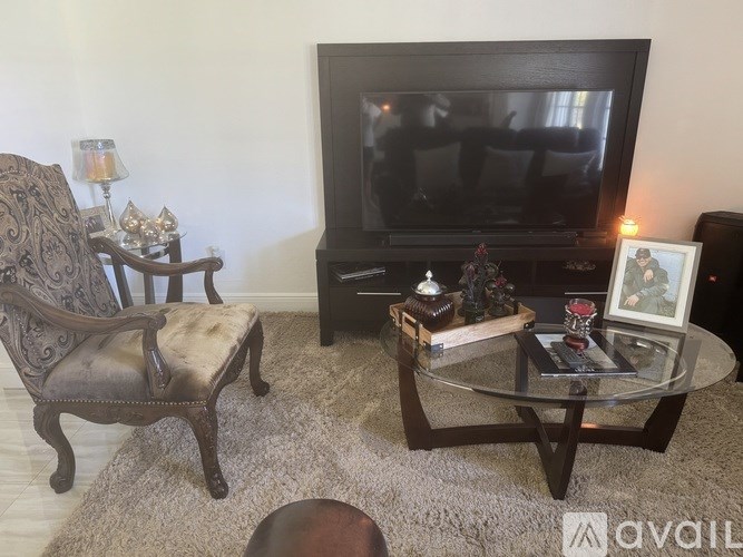 A living room with a couch, chair, and a table with a vase on it.