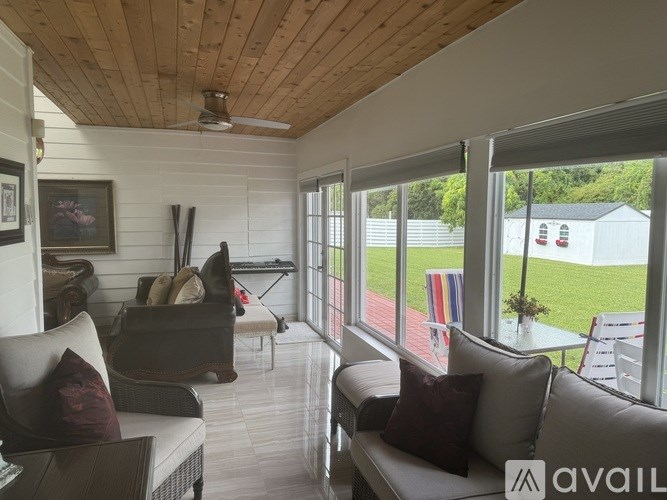 A living room with a couch, chairs, and a ceiling fan.