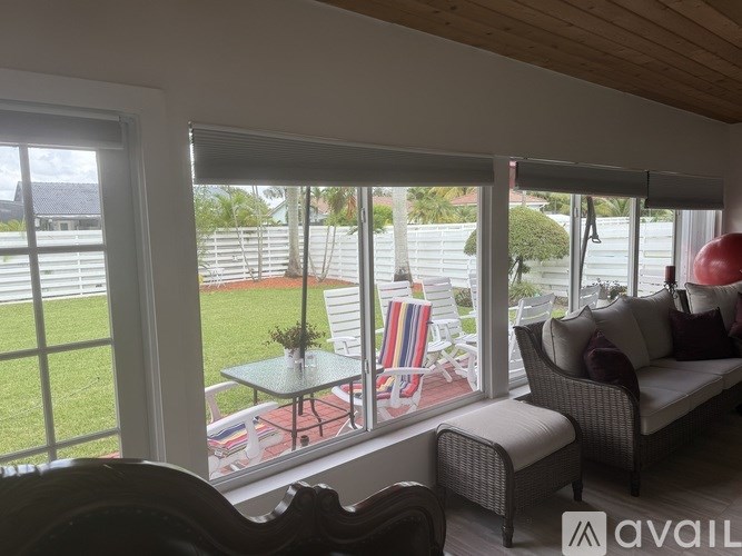 A living room with a couch, chair, and table with a vase of flowers on it.