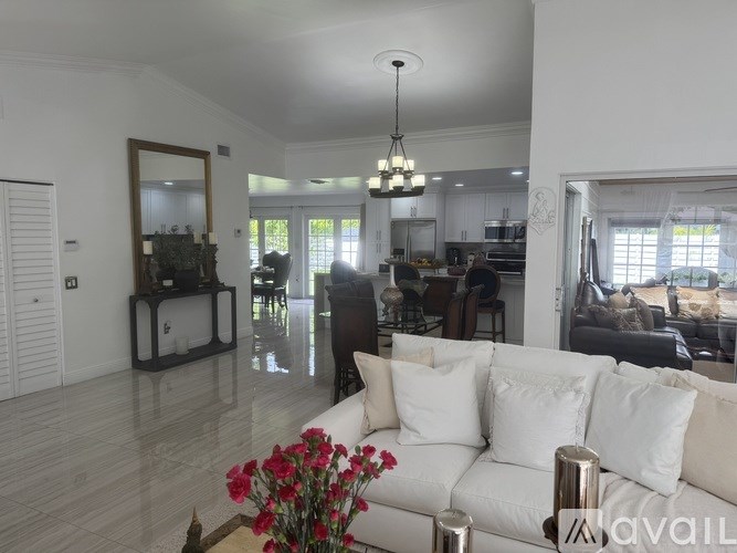 A living room with a white couch and a chandelier.