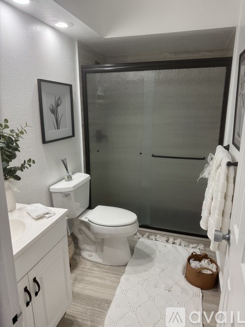A living room with a white couch, a coffee table, and a fireplace.