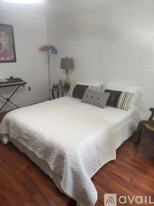 An American flag flies next to a flag with white text on a flagpole.