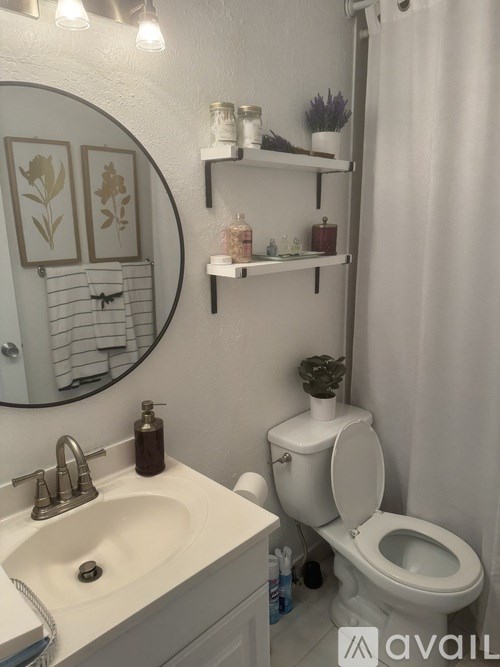 A bathroom with a toilet, sink, and shelves above it.