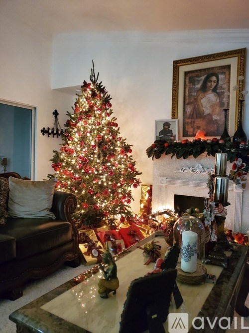 A Christmas tree is decorated with lights and ornaments in a living room.
