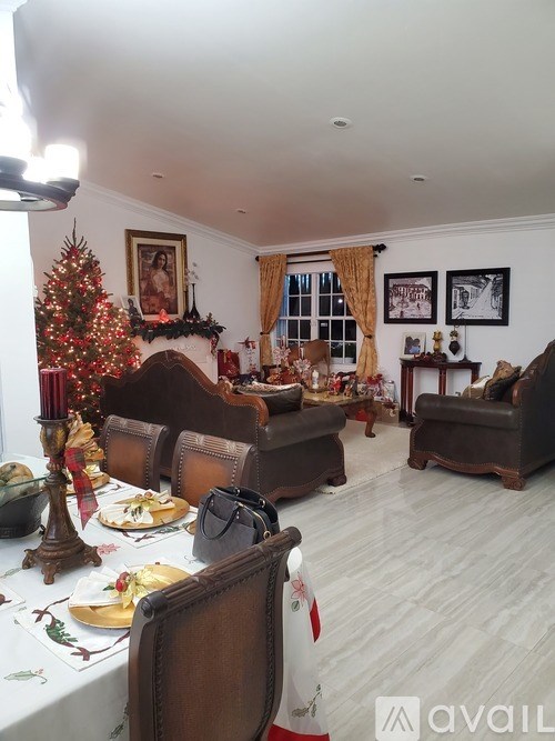 A living room with a Christmas tree and a dining table set for a meal.