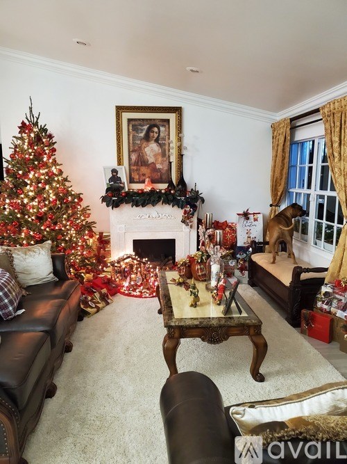 A living room with a Christmas tree and a fireplace.