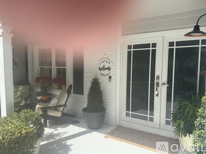 A white house with a glass door and a sign on the wall.