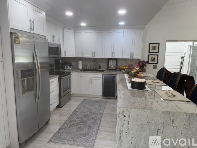 A modern kitchen with stainless steel appliances and white cabinets.
