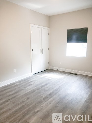 A room with a white door and a window with blinds.
