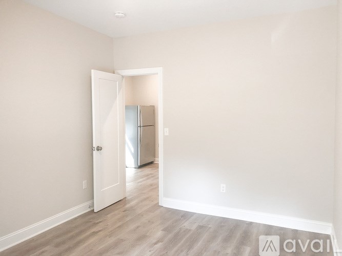 A room with a white door and a white wall.