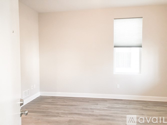A room with a window and wooden flooring is available for rent.