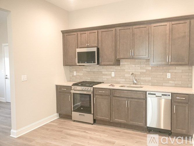 A kitchen with wooden cabinets and a stainless steel dishwasher.