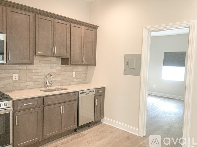A kitchen with brown cabinets and a white sink.