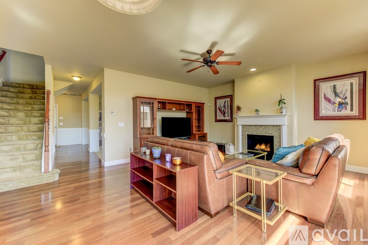 A living room with a brown leather couch and a glass coffee table.