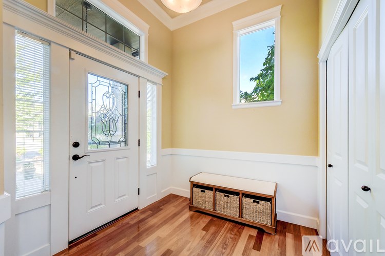 A room with a white door, a window, and a bench.