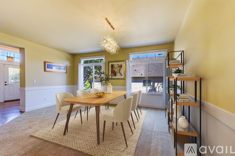 A dining room with a wooden table and chairs.