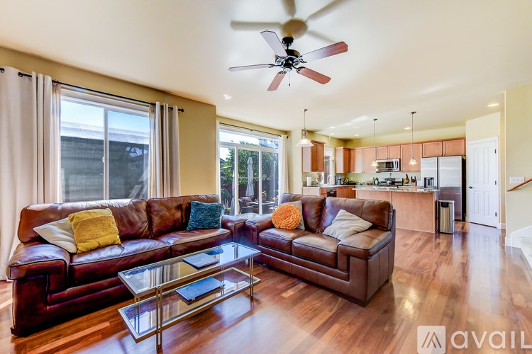 A living room with a brown leather couch and a glass coffee table.
