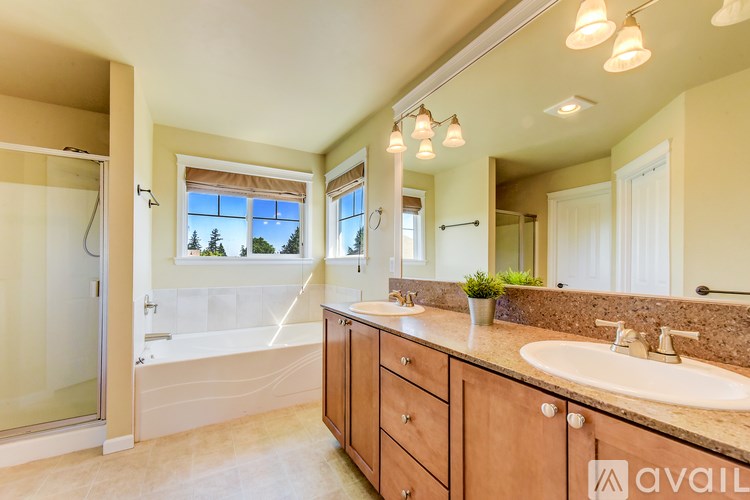 A bathroom with a tub, sink, and mirror.