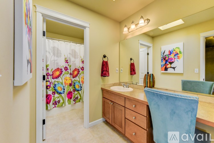 A bathroom with a wooden vanity and a mirror above it.